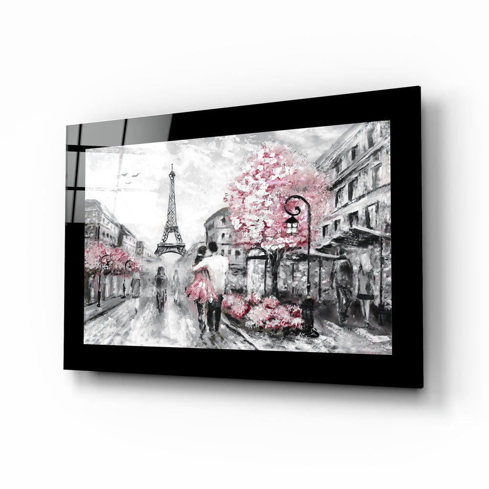 Black-framed glass wall art displaying a Paris street scene in grayscale with pink flowering trees and the Eiffel Tower, mounted at an angle.