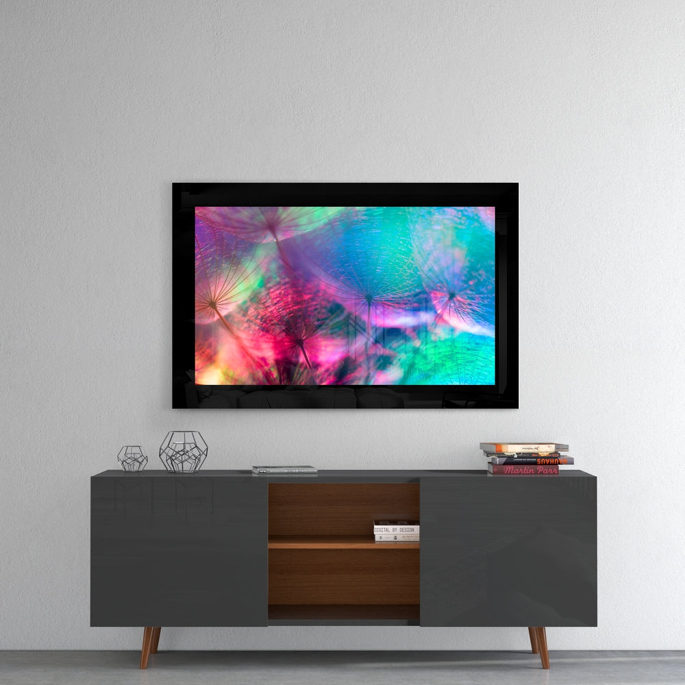 Vibrant dandelion glass art displaying pink, blue, and green hues mounted on gray wall above mid-century modern console table.
