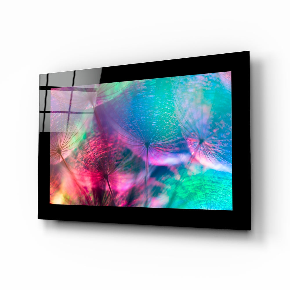 Black-framed glass wall art displaying vibrant multicolored dandelions in pink, turquoise, and green, mounted at an angle.