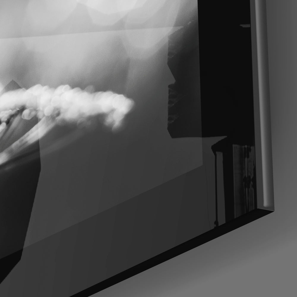 Close-up of frosted glass wall art showing white cloud formations against gray tones, mounted at an angle.