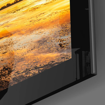 Side angle view of framed glass wall art displaying golden and orange desert landscape with textured terrain against black frame.