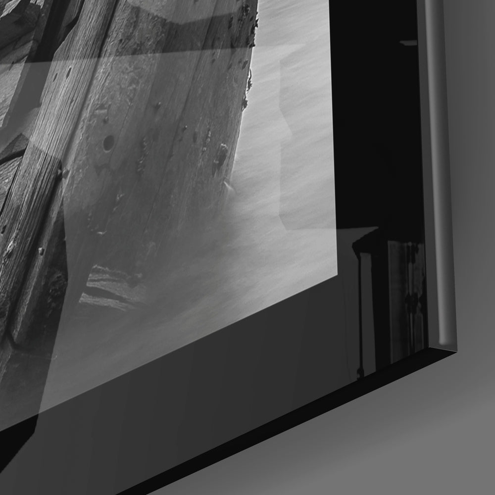 Black and white glass wall art displaying close-up detail of weathered wooden boat hull with visible grain and deterioration.