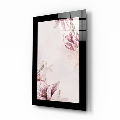 Black-framed glass wall art displaying pink floral botanical design with gold accents on cream background, angled perspective view.
