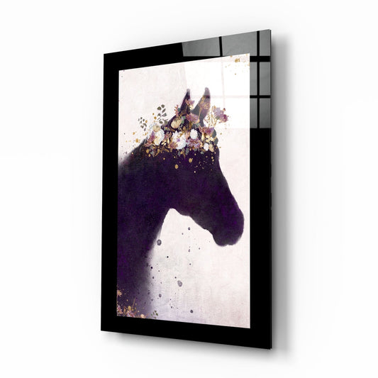 Angled view of framed glass wall art depicting a dark purple horse head with gold and floral watercolor splashes, black frame visible.
