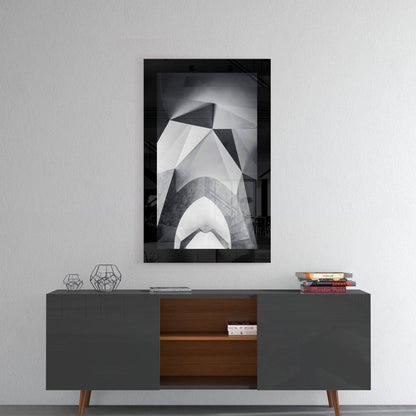 Black and white framed glass art depicting abstract architectural forms displayed above a mid-century modern credenza.