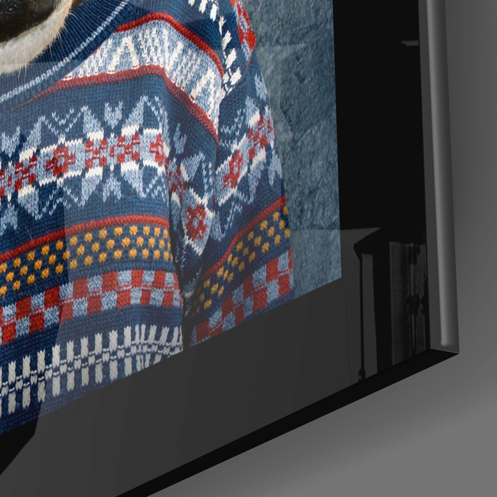 Close-up side view of framed glass wall art displaying a knitted sweater pattern with navy, red, white, and gold geometric designs.
