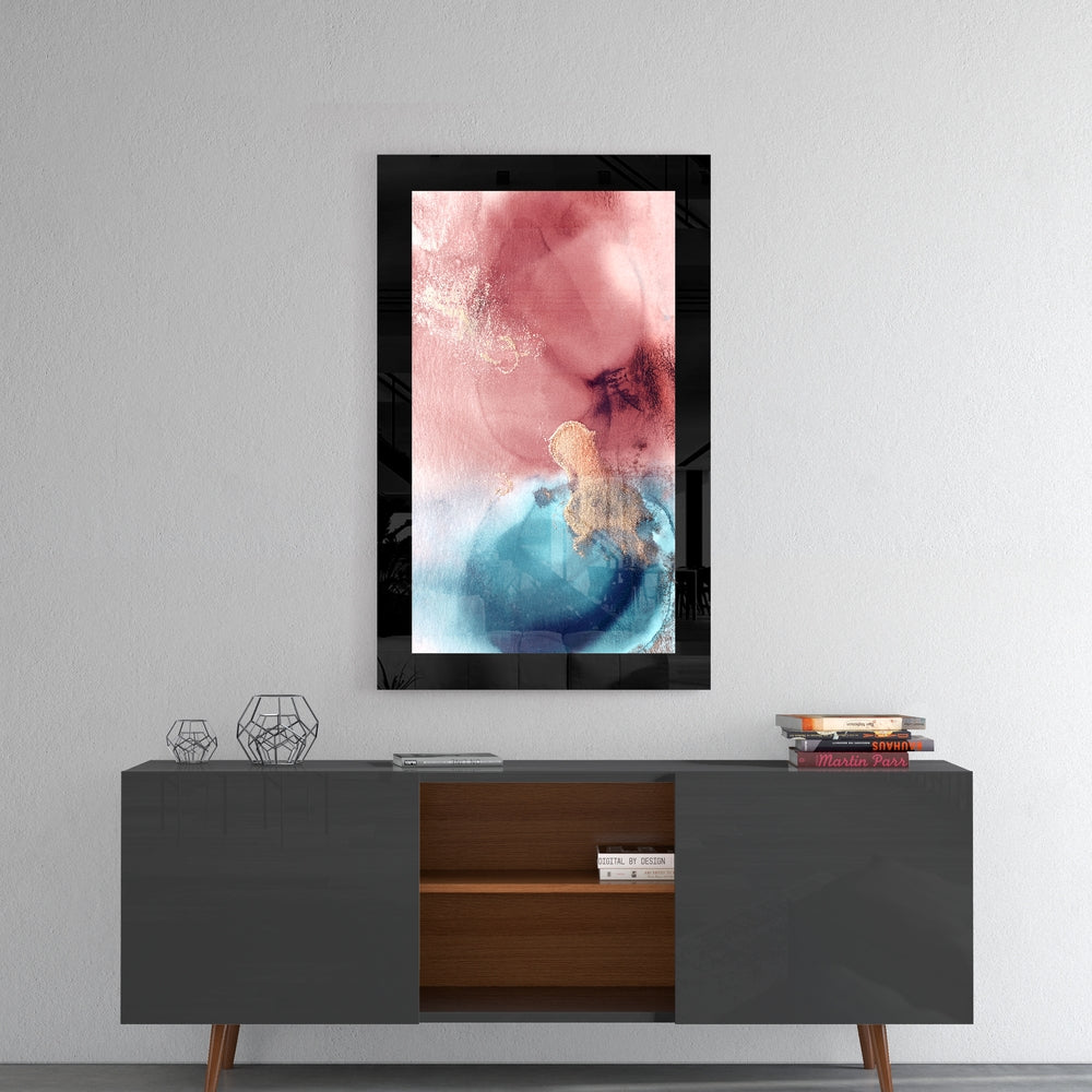 Black-framed glass wall art displaying pink and blue watercolor abstract design, hung above mid-century modern credenza.