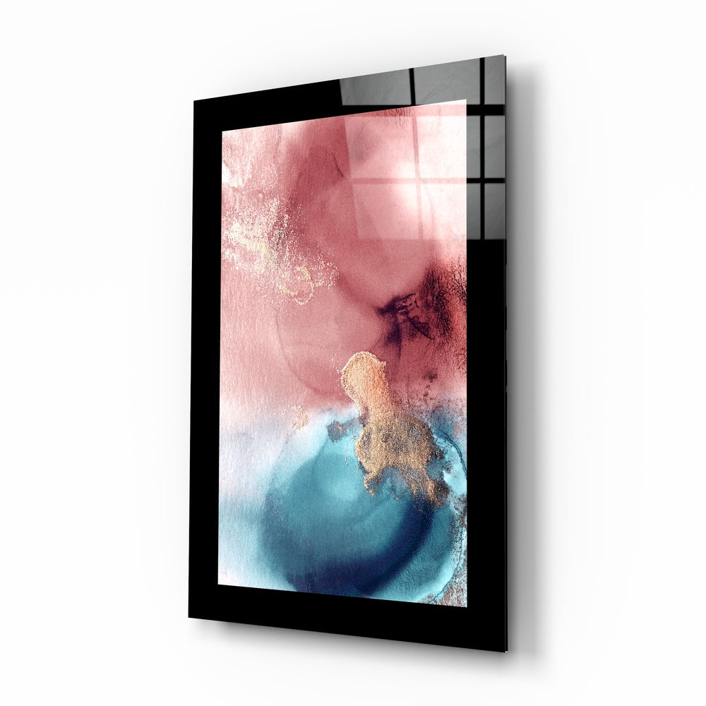 Black-framed glass wall art displaying abstract pink and blue watercolor composition with gold accents, angled perspective view.