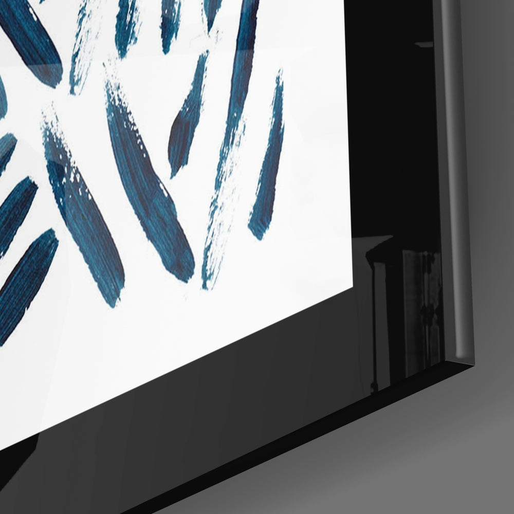 Angled view of glass wall art with blue and white brushstroke design mounted on gray wall.