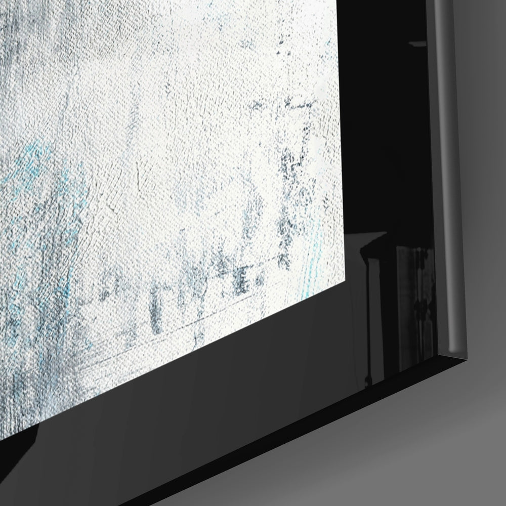 Close-up angle of blue and white textured glass wall art mounted in black frame against gray wall.