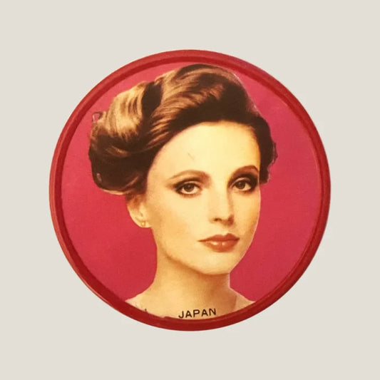 Glamorous vintage red button featuring actress portrait on a striking red background