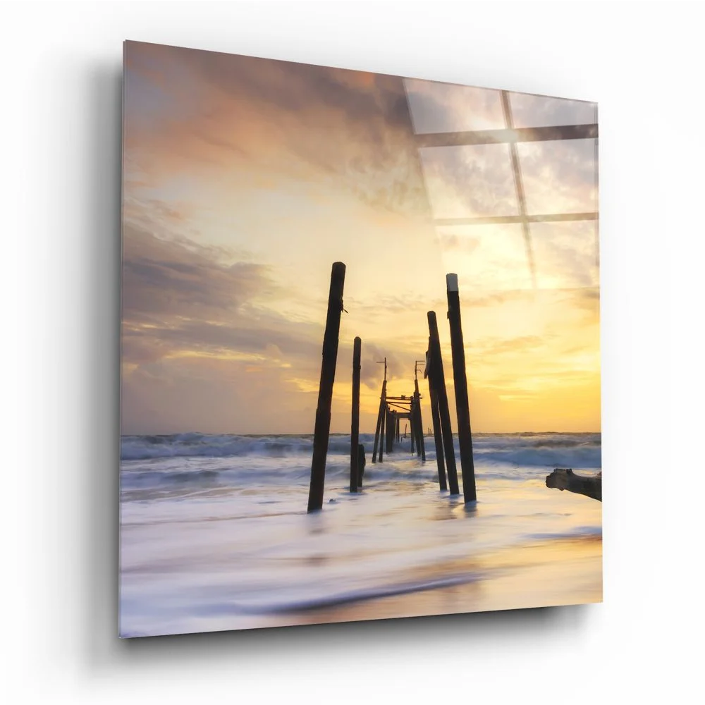 Stunning ocean sunset tempered glass art with silhouetted pier pilings
