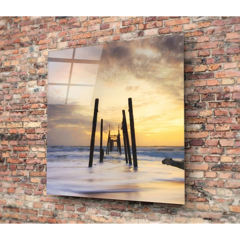 Stunning ocean sunset tempered glass art with silhouetted pier on brick wall
