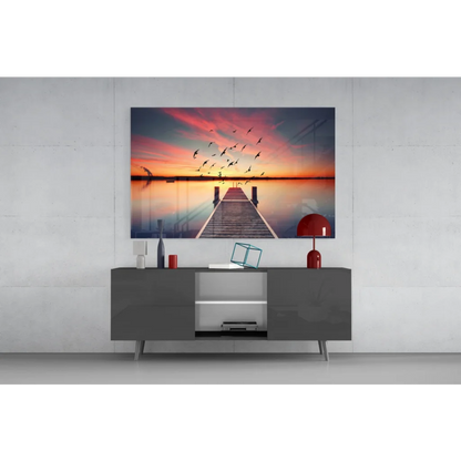 Vibrant sunset glass wall art print of pier and silhouetted birds