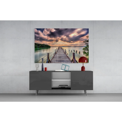 Stunning glass wall art of wooden pier in calm water under colorful sky