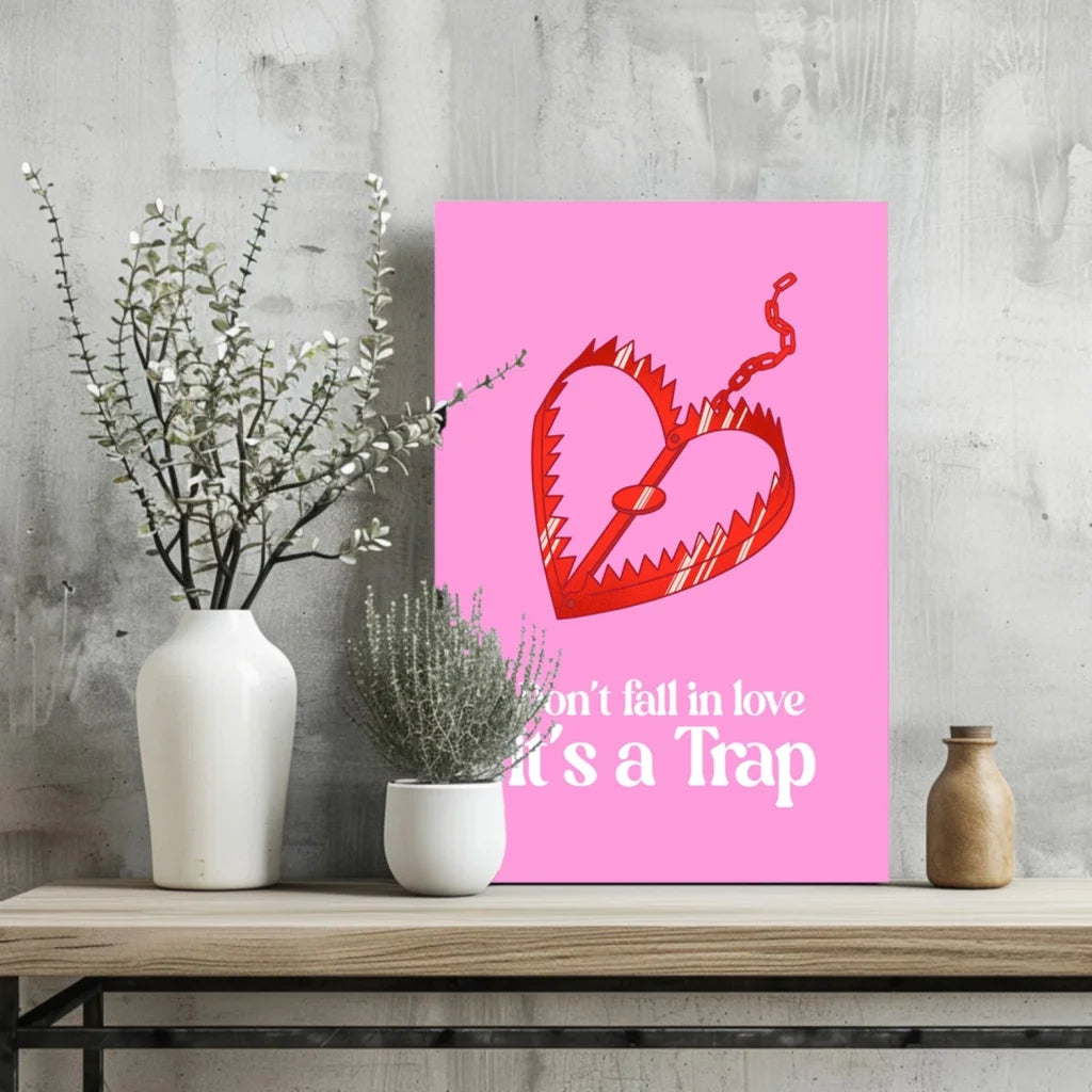 Pink heart-shaped mousetrap poster on wooden shelf: Don’t Fall in Love It’s a Trap