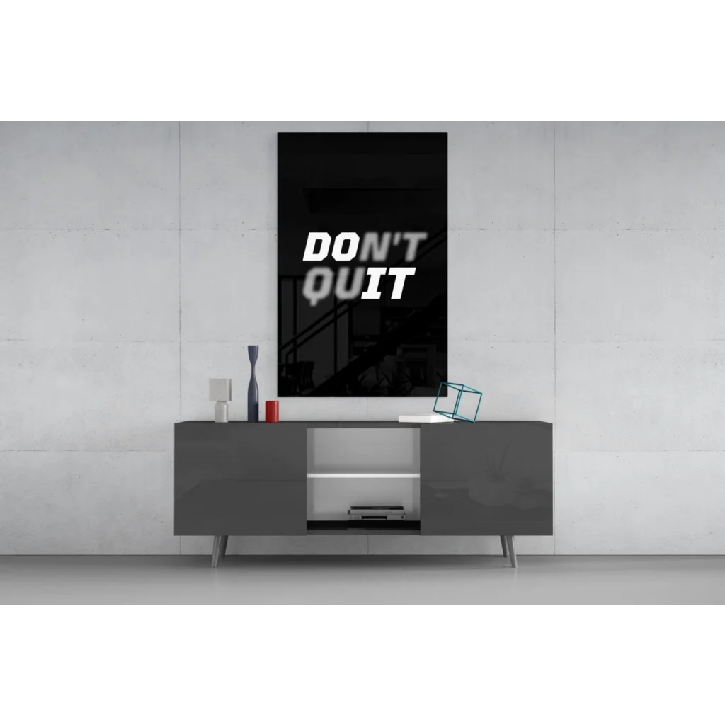 Black framed Dont Quit motivational wall art above gray console