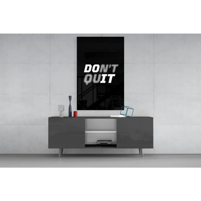 Black framed Dont Quit motivational wall art above gray console