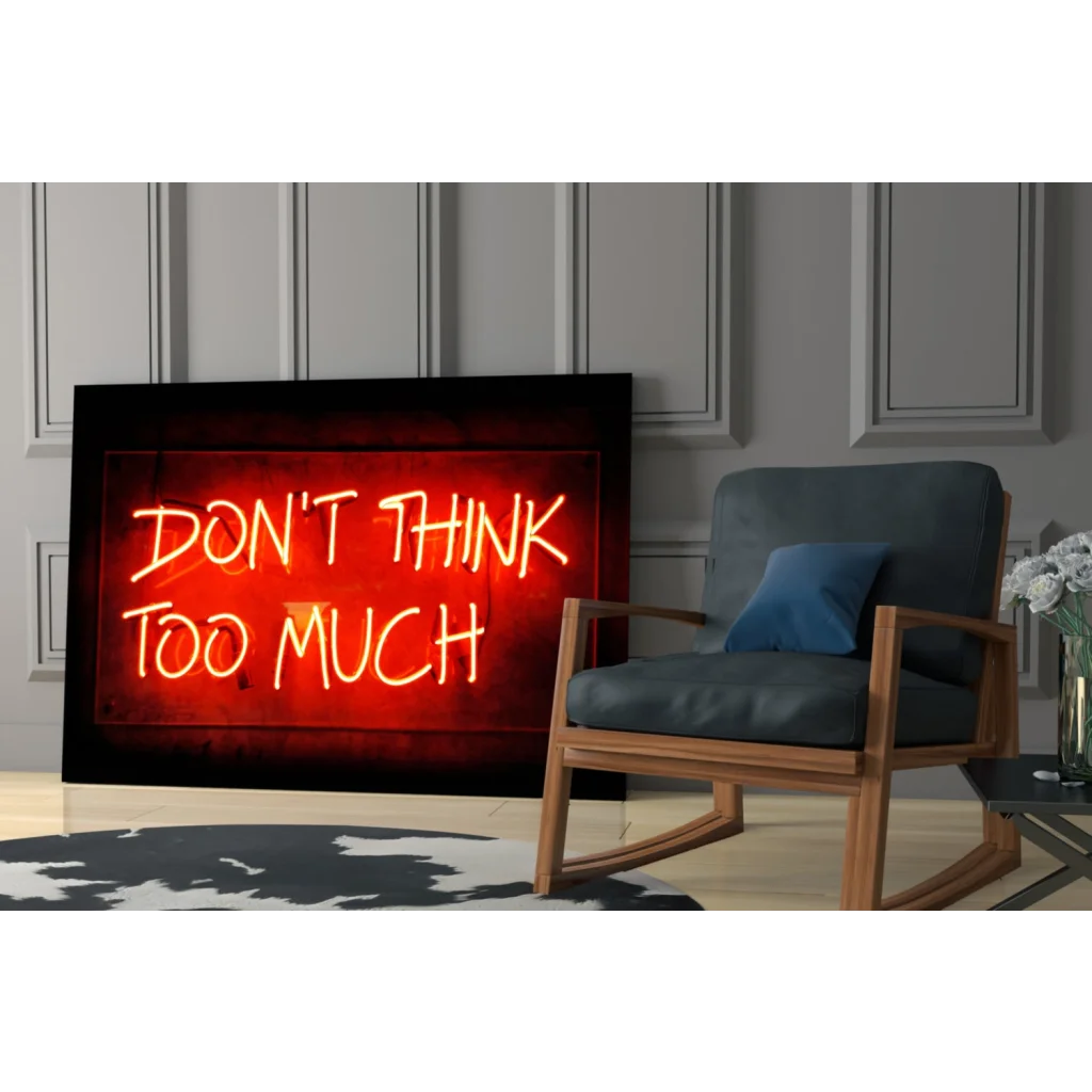 Glowing red neon glass wall art sign with dont think too much in yellow-orange