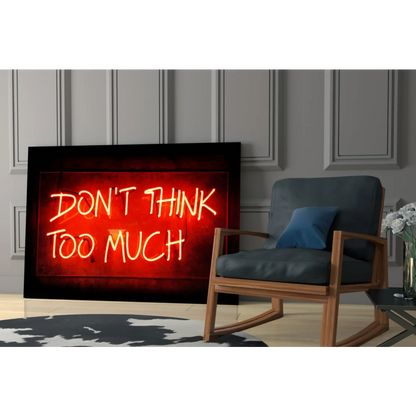 Glowing red neon glass wall art sign with dont think too much in yellow-orange