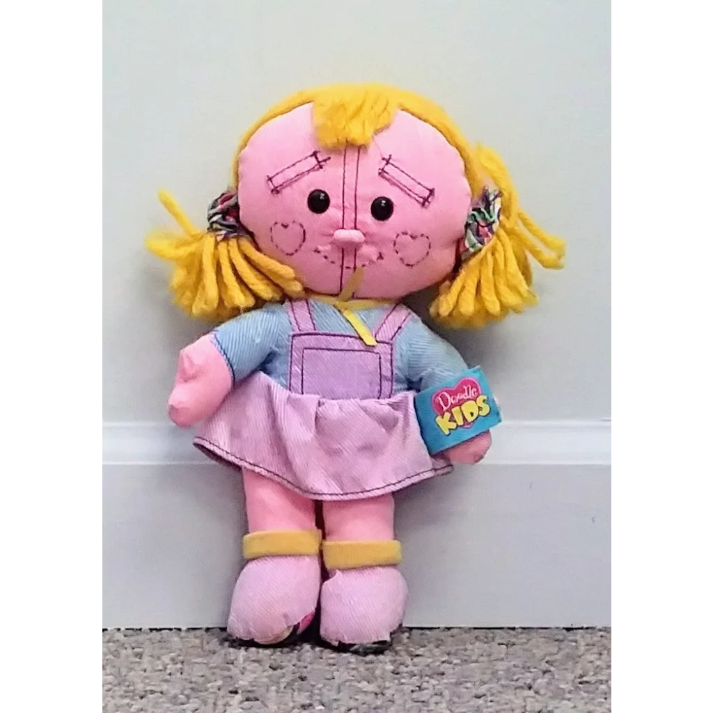 Vintage 1996 Tyco Doodle Kids doll in pink with yellow hair and blue overalls holding book
