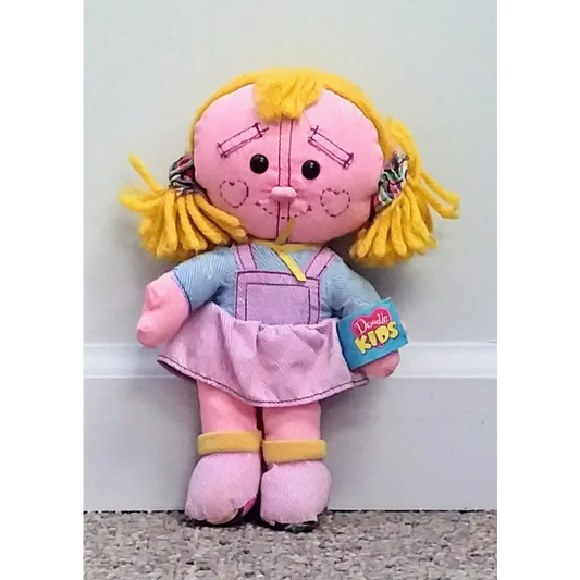 Vintage 1996 Tyco Doodle Kids doll in pink with yellow hair and blue overalls holding book