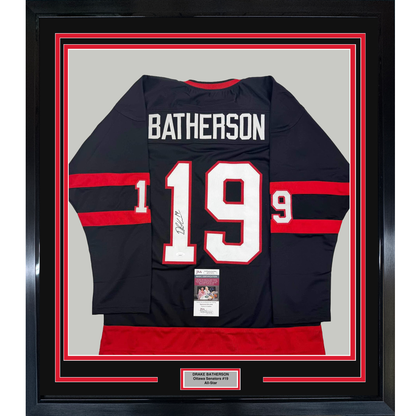 Framed front view of black and red striped Ottawa Senators hockey jersey #19 Batherson with white lettering and JSA authentication certificate.