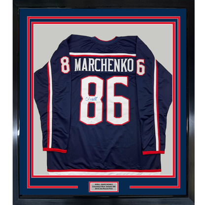 Framed navy Columbus Blue Jackets jersey with Marchenko #86 and autograph, displayed back view against red and blue matting.
