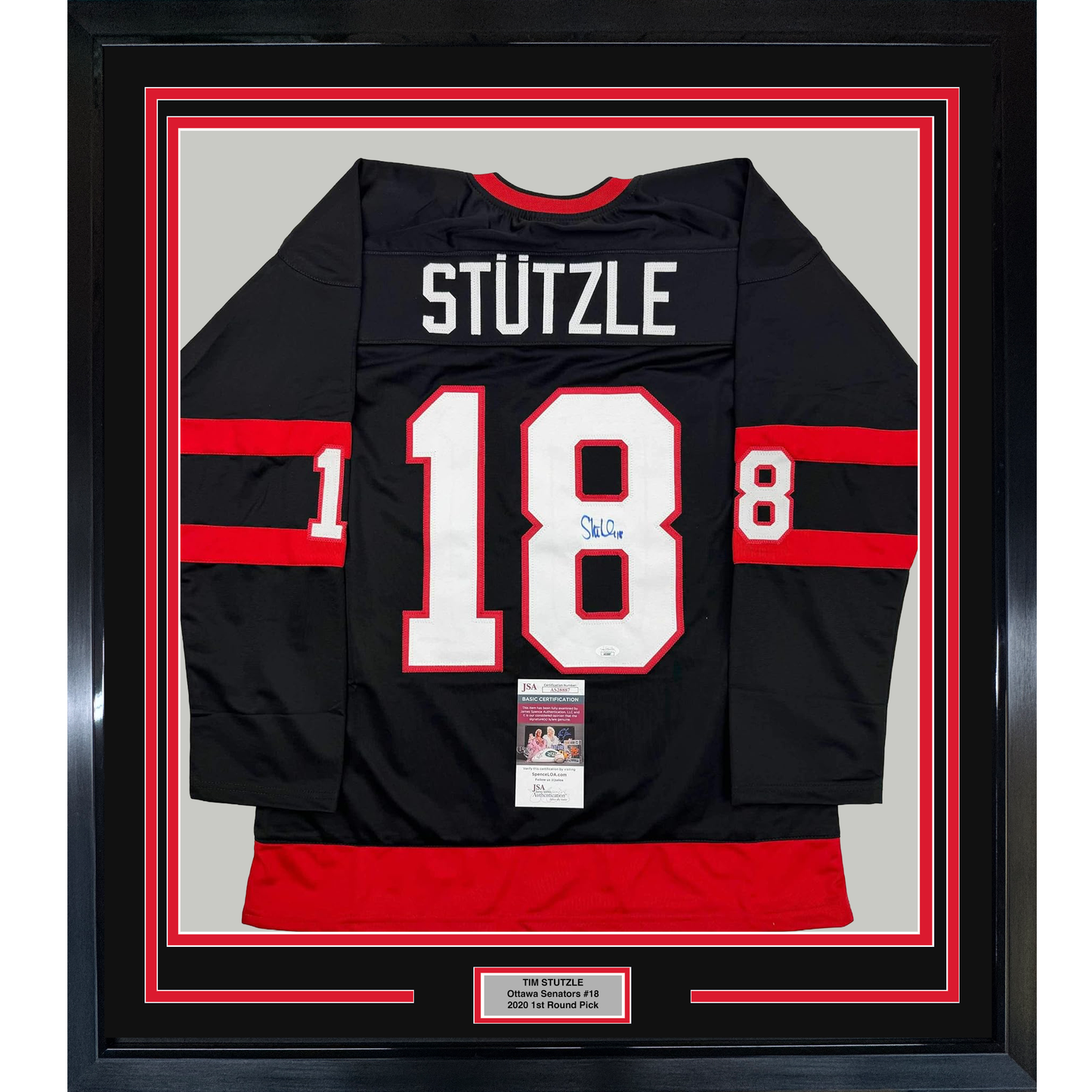 Black Ottawa Senators hockey jersey number 18 with "STUTZLE" nameplate, signed, displayed framed with red and white matting.