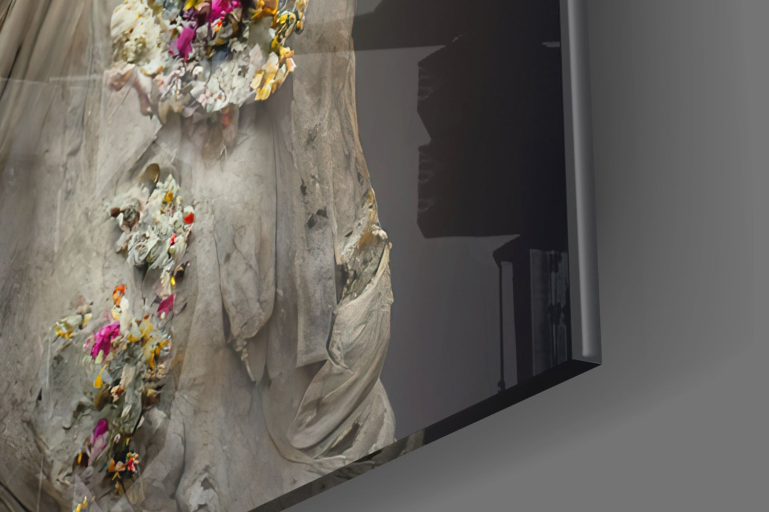 Close-up of textured stone wall art with colorful flowers (pink, yellow, orange) embedded in white plaster, beside a dark doorway opening.