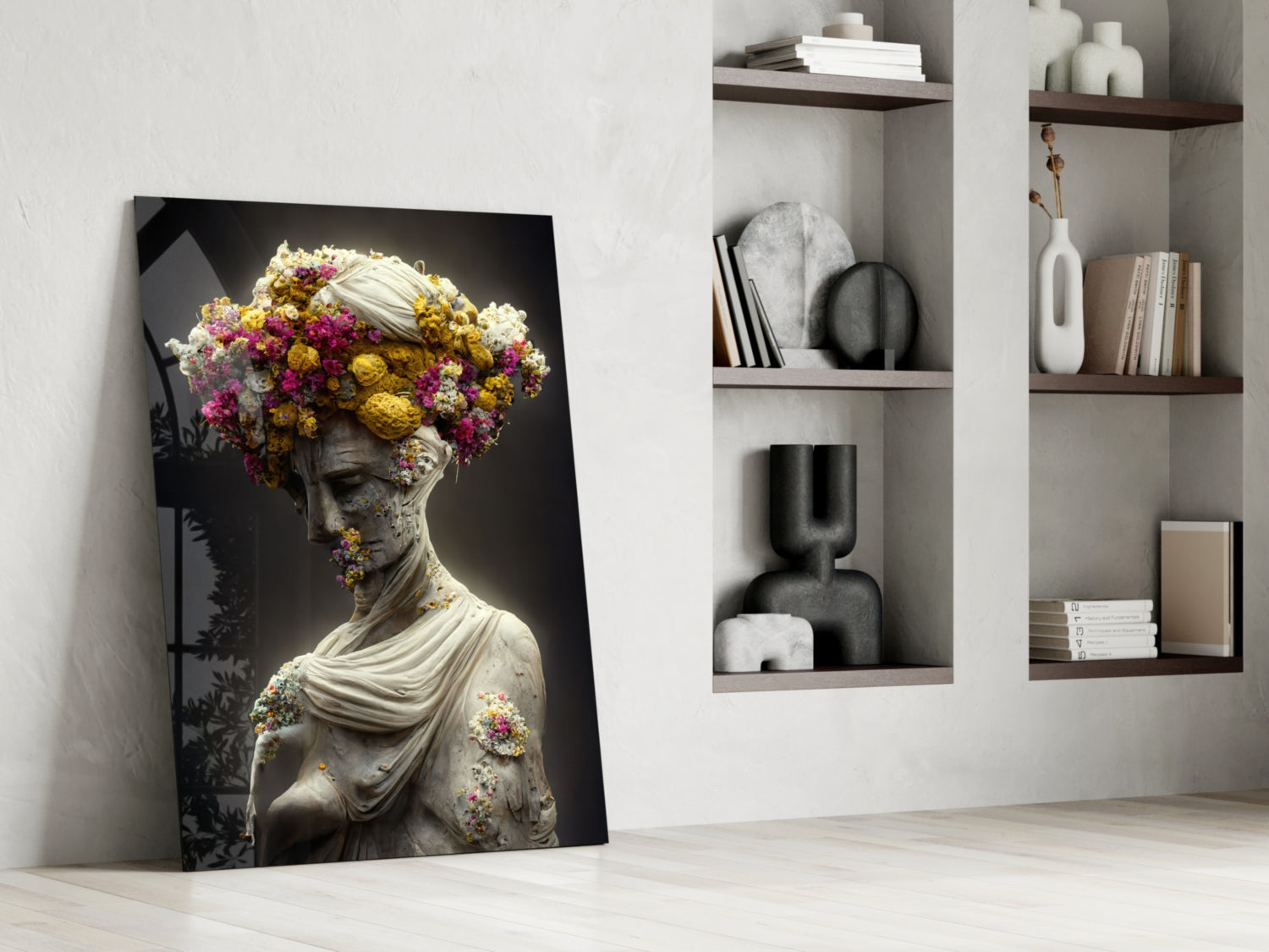 Glass wall art leaning against white wall shows classical statue with colorful flowers adorning head and shoulders against dark background.