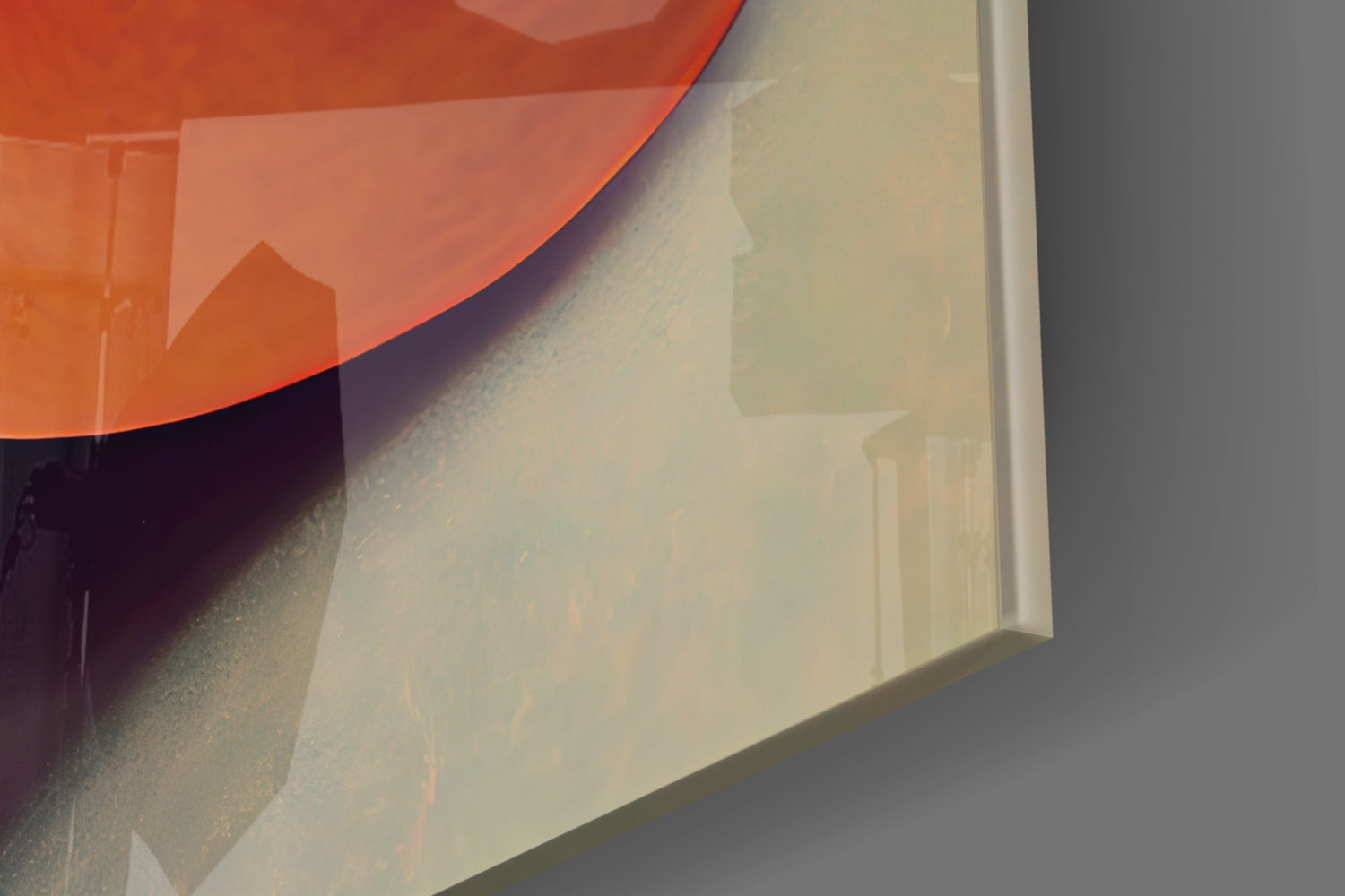 Close-up angled view of translucent frosted glass art piece with red and cream curved surfaces and subtle interior details.