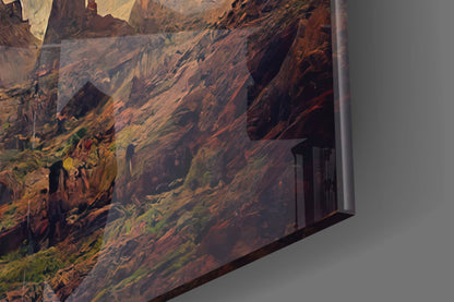 Close-up angled view of glass art panel showing textured brown, orange, and yellow layered landscape with cave openings against gray background.