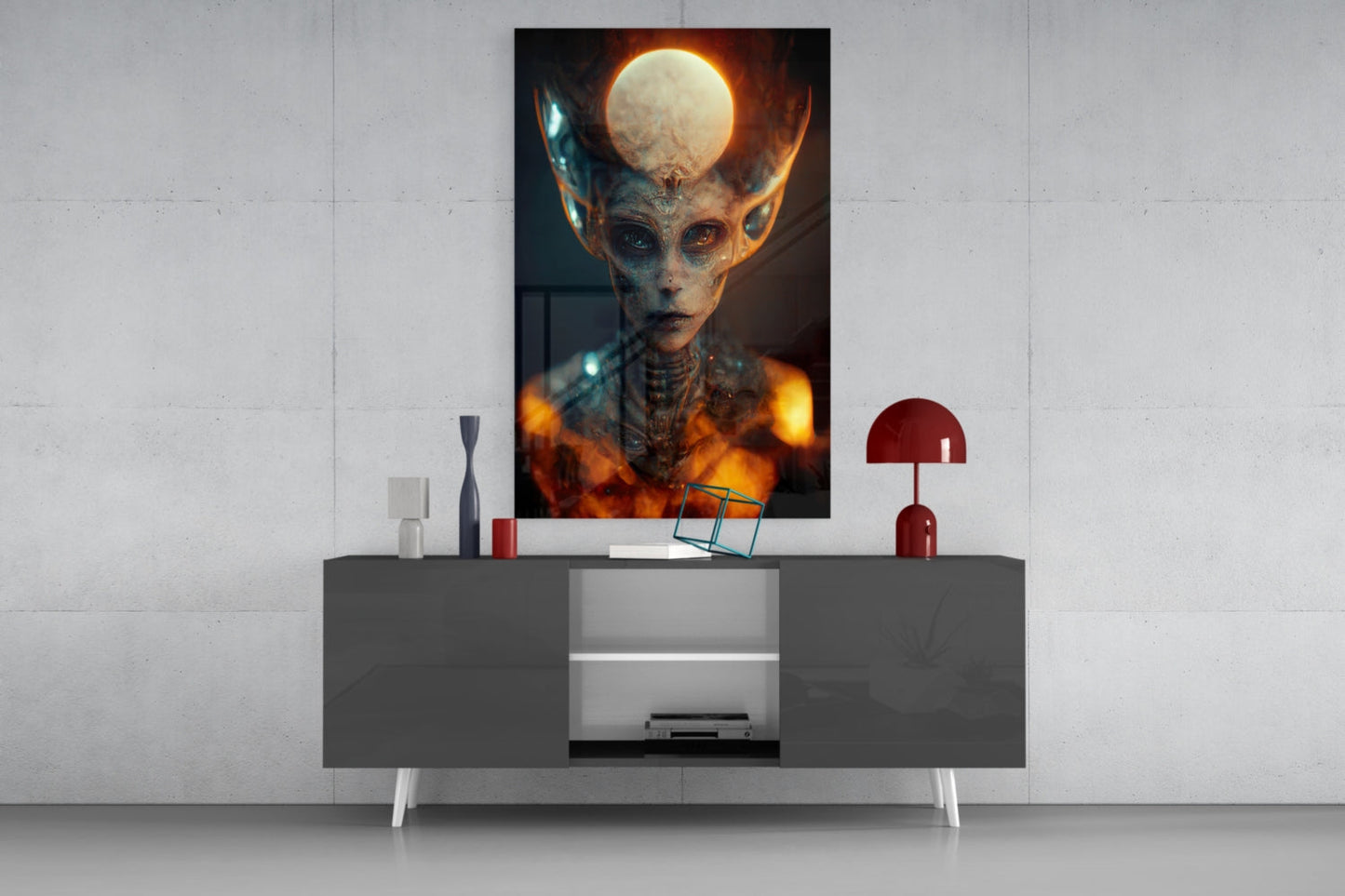 Framed glass art print displayed above a modern gray console table, depicting an alien figure with glowing moon headdress and fiery orange aura.