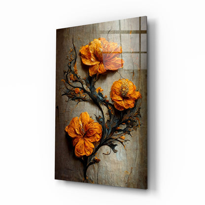 Three vibrant orange flowers with dark branches on a textured gray background, displayed on angled glass panel showing shadow and depth.