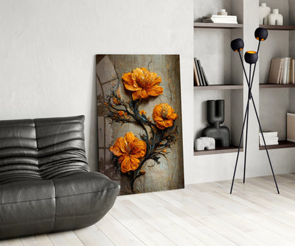 Modern living room with glass art featuring three orange flowers on dark branches, displayed against white wall beside gray leather chair and black floor lamp.