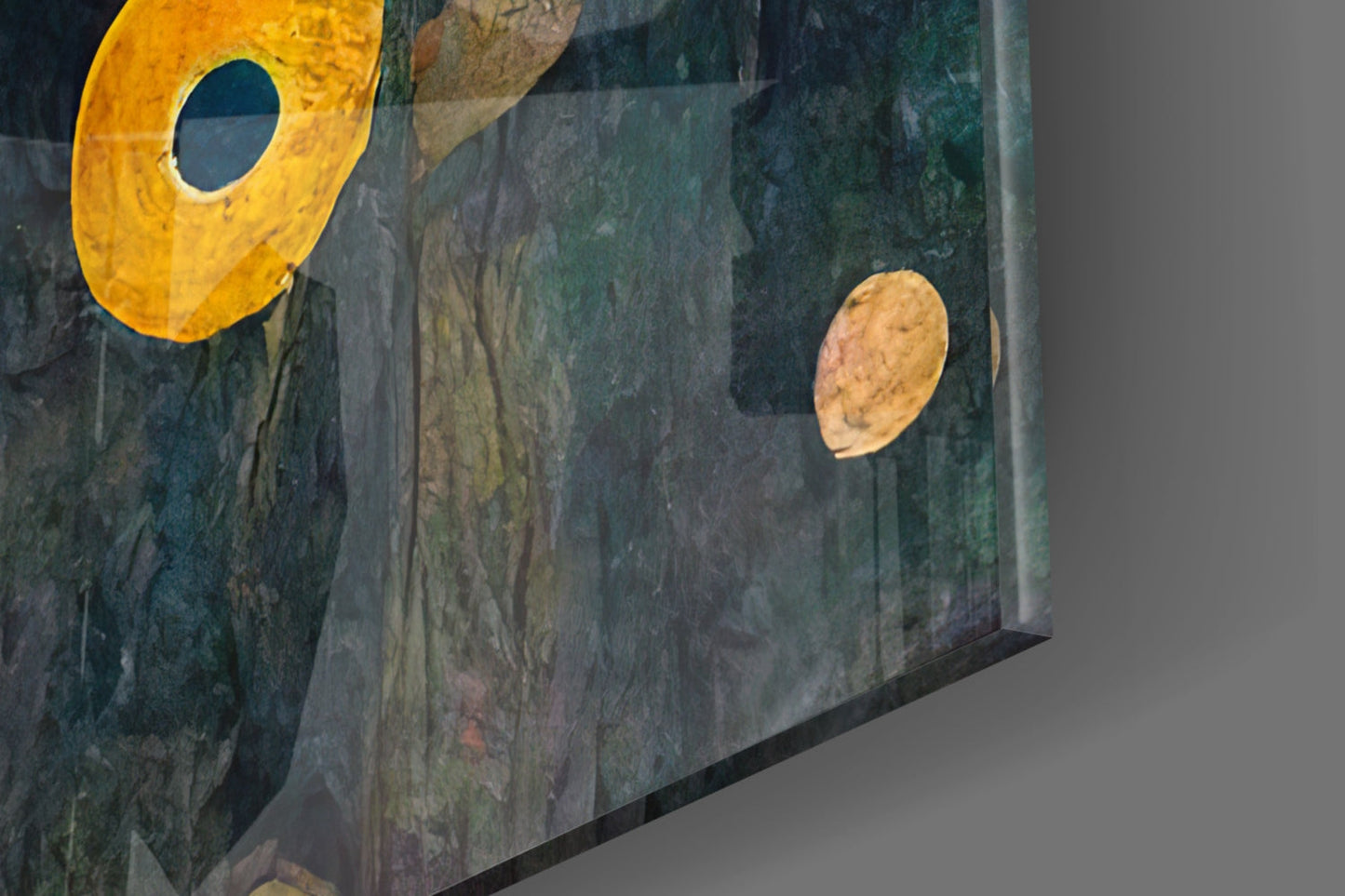 Close-up angled view of textured teal-green glass wall art with yellow circular element and tan leaf shape against neutral background.