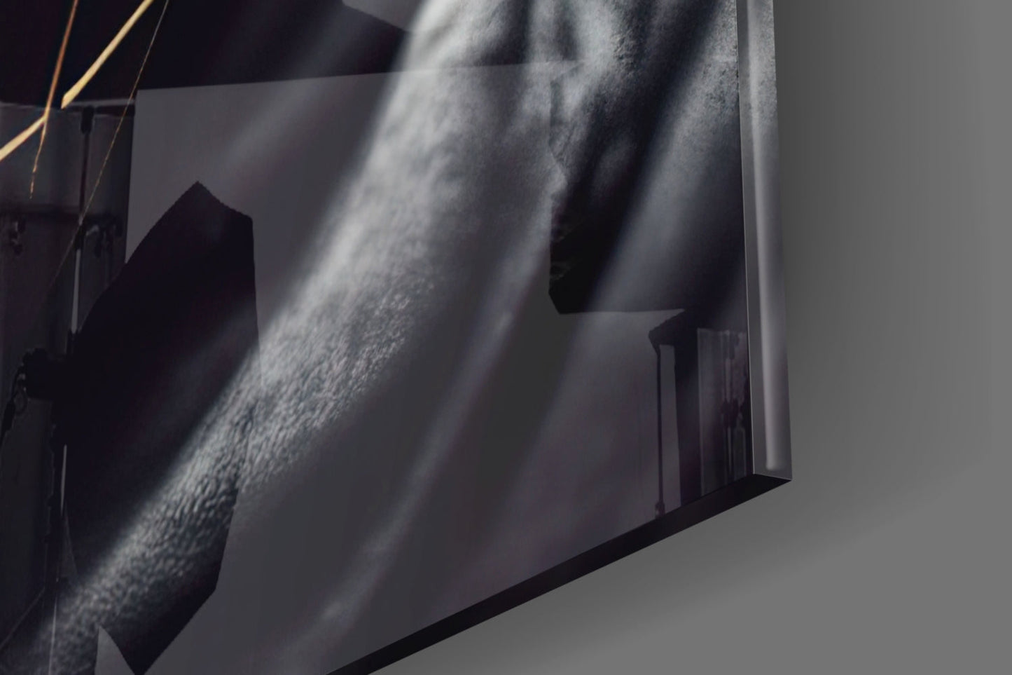 Close-up detail of textured glass surface with dramatic light rays casting shadows across grey and white tones.