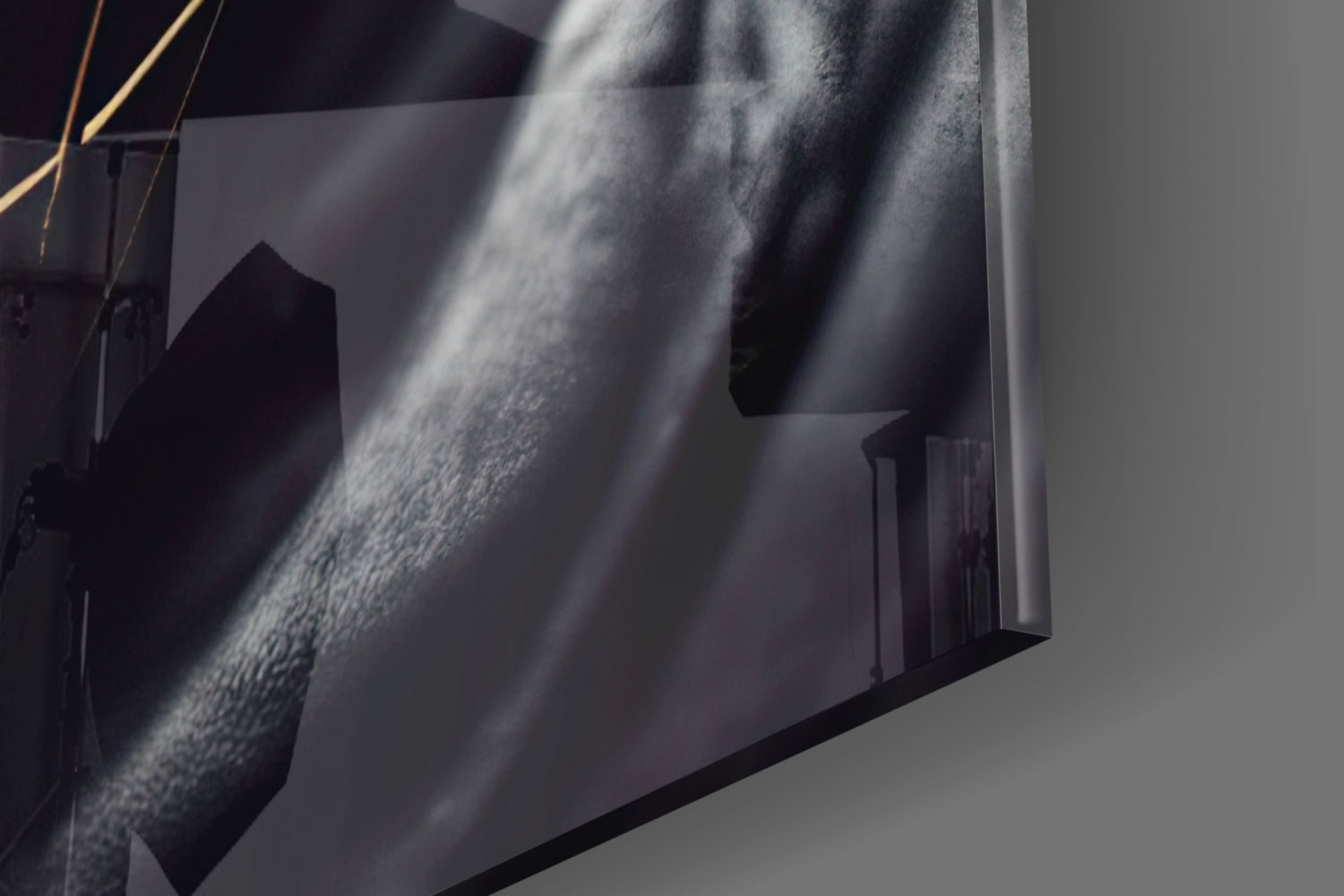 Close-up detail of textured glass surface with dramatic light rays casting shadows across grey and white tones.