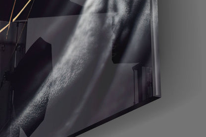 Close-up detail of textured glass surface with dramatic light rays casting shadows across grey and white tones.