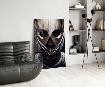 Black and gold geometric mask artwork displayed in modern living room with grey sofa, shelving, and floor lamp.