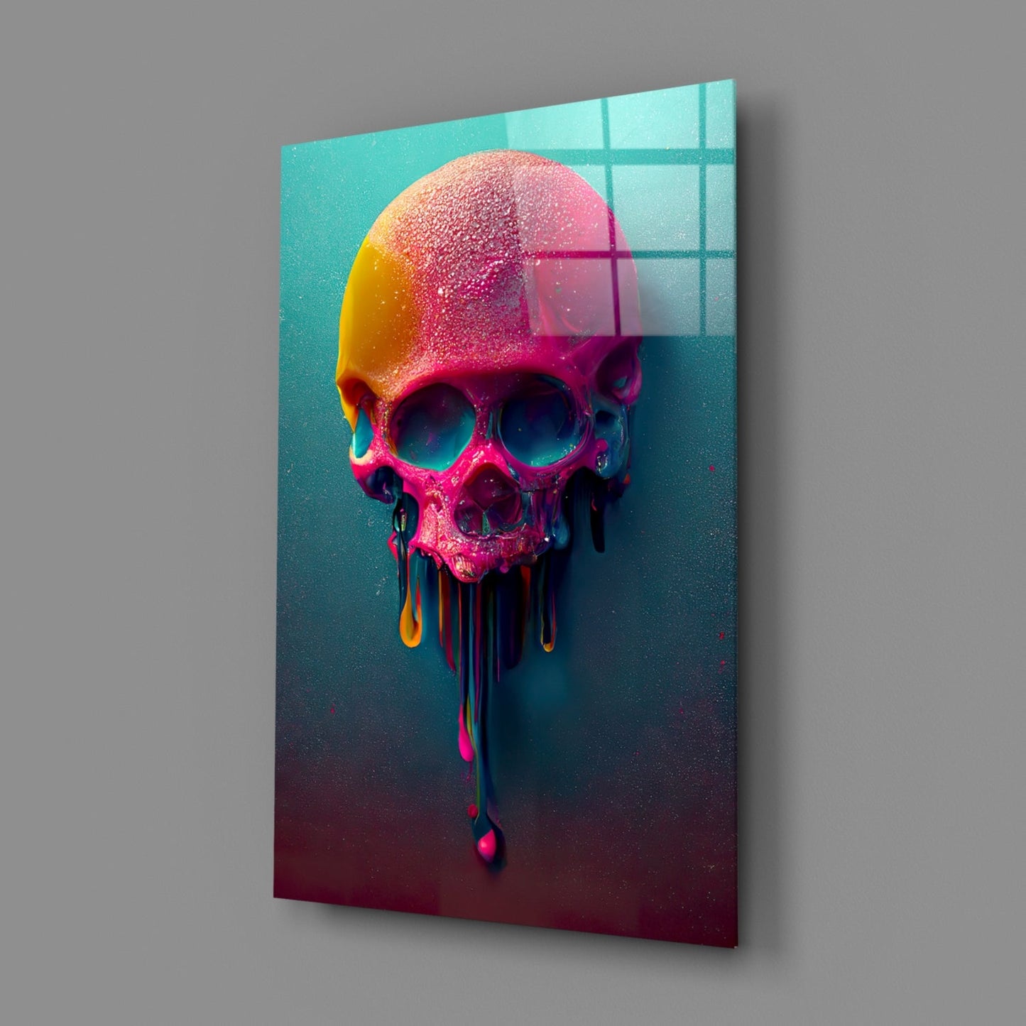 Colorful melting skull glass art displayed at an angle against gray wall, showing neon pink, yellow, and teal gradient with dripping effect.