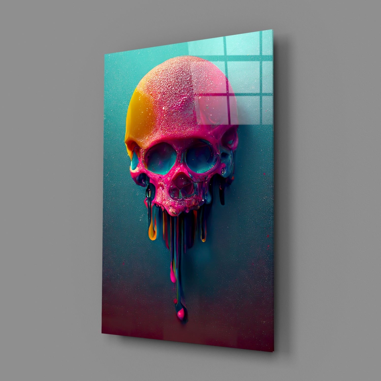 Colorful melting skull glass art displayed at an angle against gray wall, showing neon pink, yellow, and teal gradient with dripping effect.