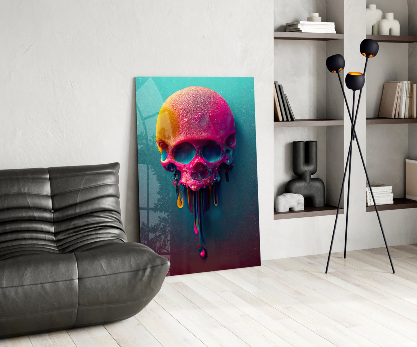 Colorful melting skull glass art displayed in modern living room with gray sofa, black floor lamp, and white shelving unit.