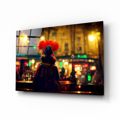 Glass art panel displayed at angle showing clown with red afro wig overlooking illuminated nighttime street scene.