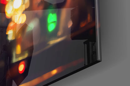 Close-up of illuminated glass art with red, yellow, and green LED lights reflecting on frosted glass surface against white wall.