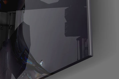 Close-up angled view of black and iridescent glass art piece against white wall, showing reflective surface detail.
