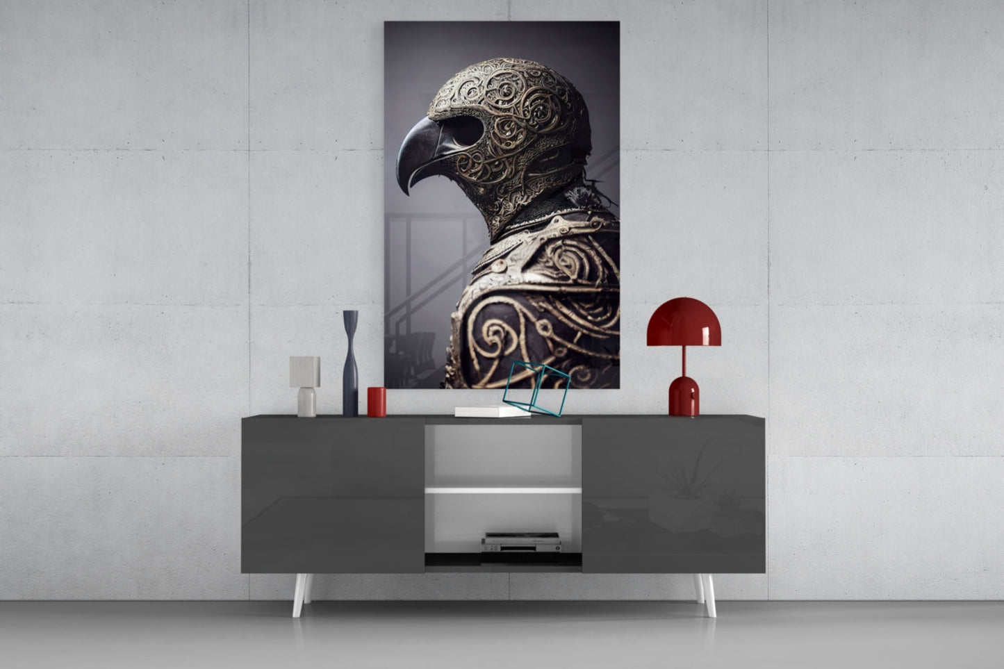 Ornate bird helmet artwork displayed on white wall above gray console table with red lamp and decorative objects.