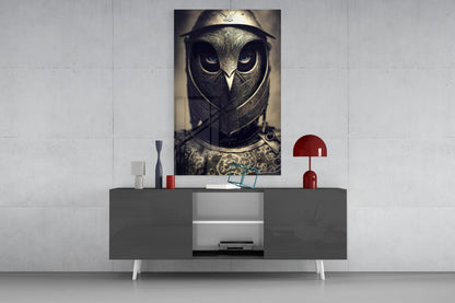 Vertical rectangular glass wall art depicting an owl warrior in metallic armor and helmet, displayed above a gray console table with red accents.