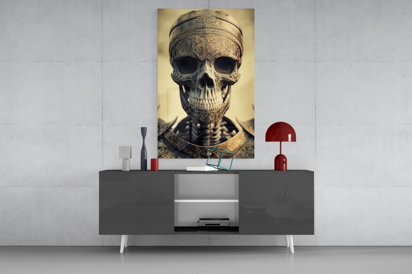 Ornate skull portrait with gold filigree headpiece displayed on white wall above gray media console with red lamp and decorative accessories.